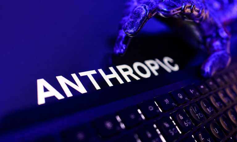Anthropic logo on a laptop screen with a robotic hand reaching over the keyboard